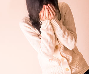 顔をで手で覆い泣く女性