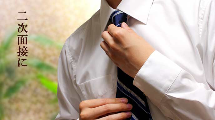 Yシャツにネクタイを締める男性