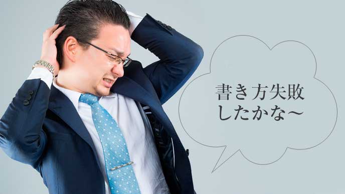 頭をかきながら後悔している男性