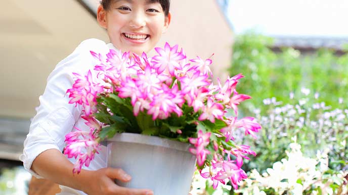花の鉢を抱えて笑顔の女性