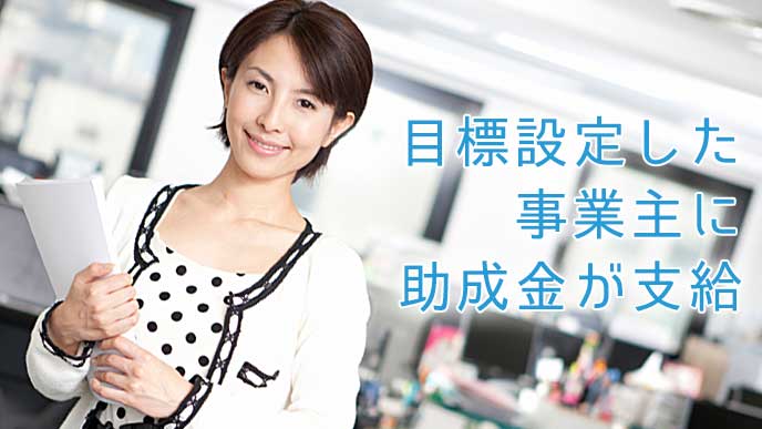 オフィスで書類を持ち微笑んでいる女性社員