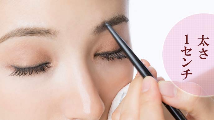 眉毛を塗る女性