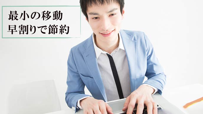 ネットで飛行機の予約をする学生