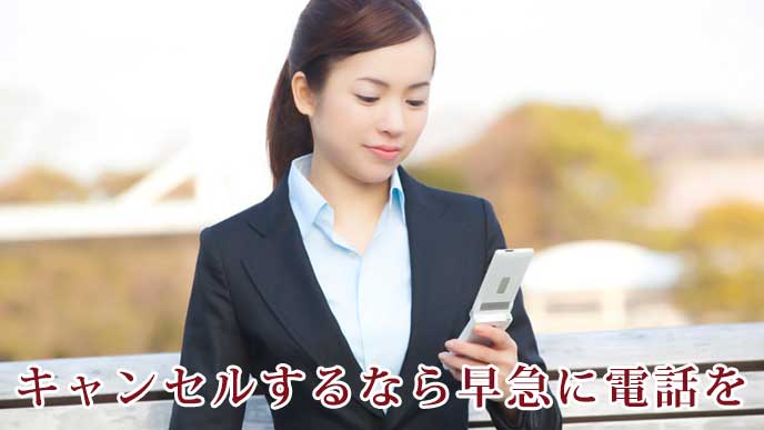 携帯電話を使っている就活生の女性