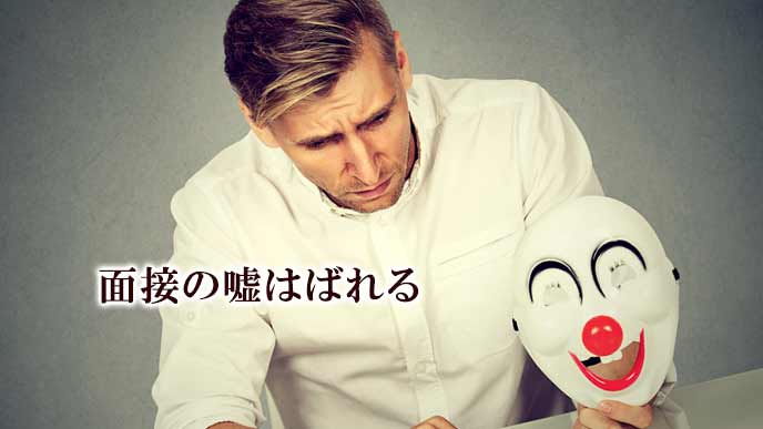 仮面を片手に持って面接する