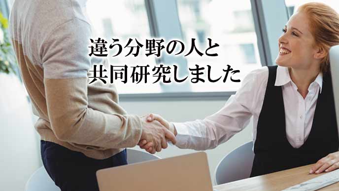 パソコンの前で握手する男女