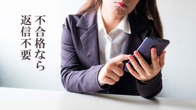 スマホでメールを読んで憮然とする女性