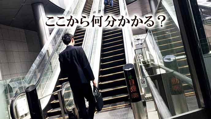 ビルの長いエスカレーターの前に立つ就活学生