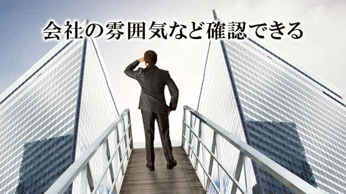 会社の前に立って眺める男性