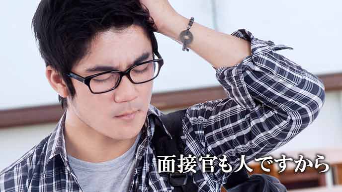 頭に手をやり反省する男性