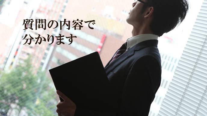 会社の窓から外を見る男性