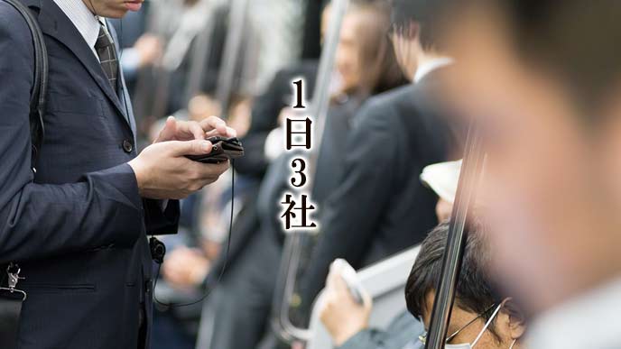 電車の中でスマホを確認する男性