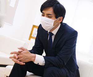マスクをして椅子に座り込む就活学生