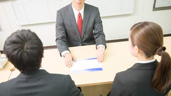 企業ブースで説明を聞く就活学生