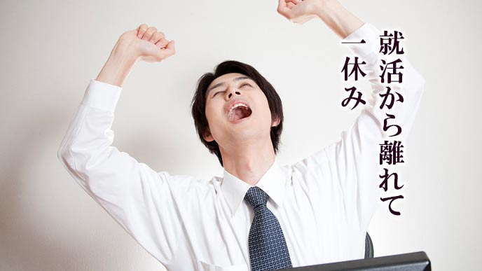 両手を上げて背伸びする就活学生