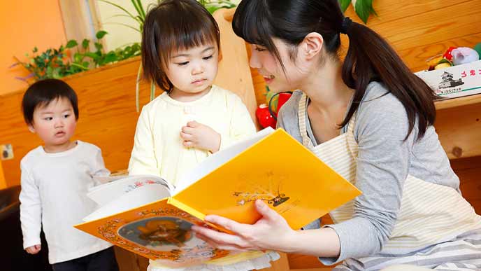 託児所で絵本を見る幼児