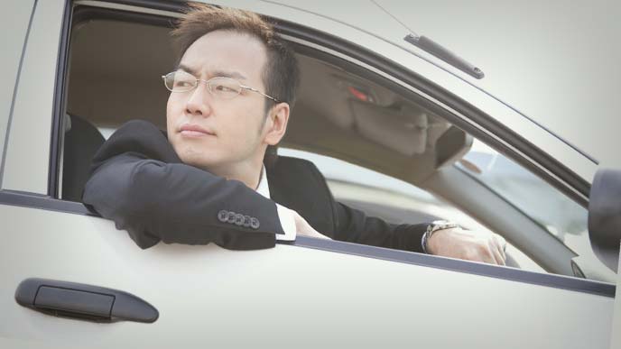車で得意先回りをする営業マン