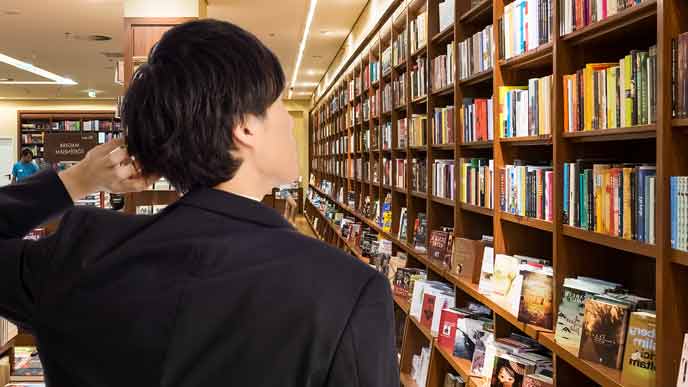 書店で本棚を探す会社員