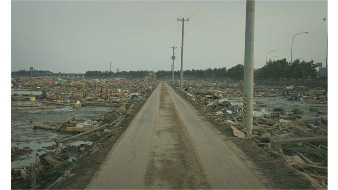 東日本大震災で被災した道路と両脇の瓦礫