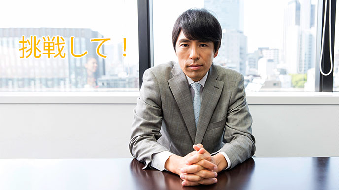 机に座って手を組む男性社員