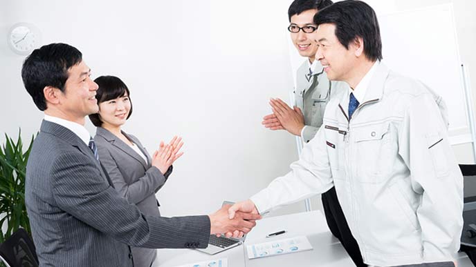 中小企業の経営者と銀行員が握手する