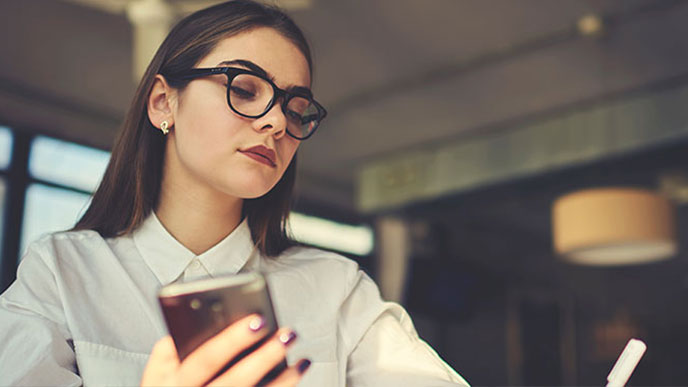 書きながらスマホを操作する女性