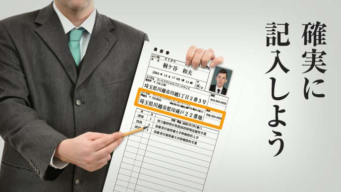 履歴書のサンプルを持ち鉛筆で指し示す男性