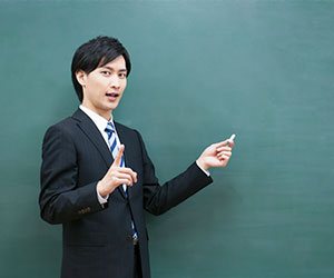 黒板の前に立つ男の人