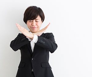 ダメばつの合図をする女の人