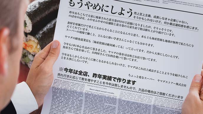 もうやめにしようの新聞広告を読んでいる男性