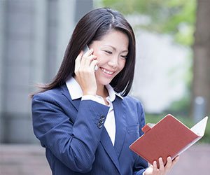 電話でアポをとる女性