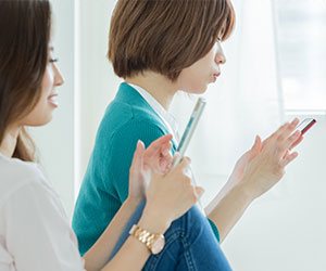 スマホを操作する女性２人