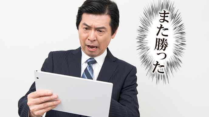 タブレットでニュースを見て驚く中年男性