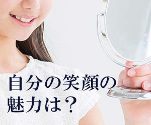 鏡で自分の笑顔を見る女性