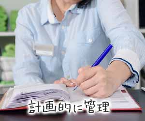 スケジュール帳に記入するマネージャ