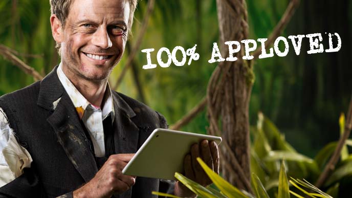 ジャングルでズタボロになりながら笑顔でタッチパッドを操作する男性