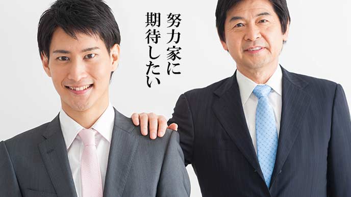 新人の肩に手を置く年配の上司
